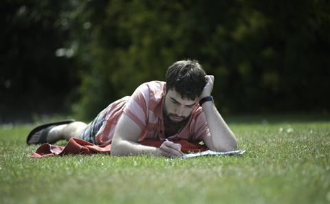 student reading on the lawn