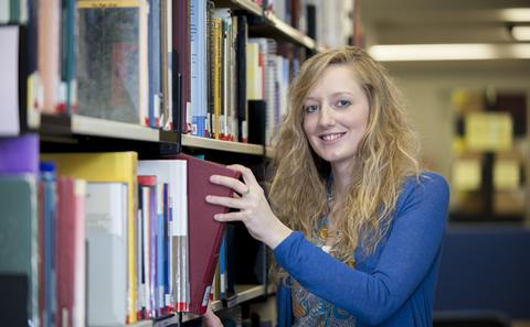 Student taking book from shelf