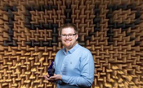 Charlie holding his award in the anechoic chamber