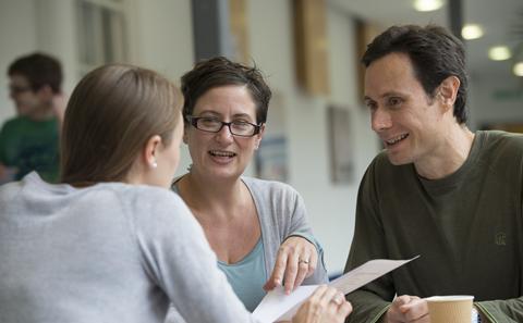 three people meeting with paper