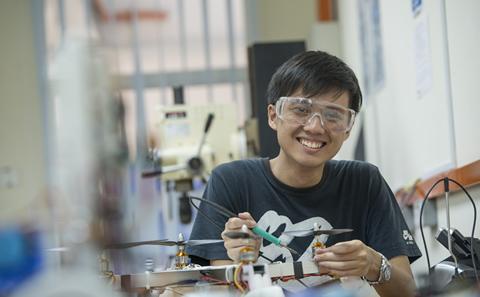 Malaysian student in workshop smiling to camera