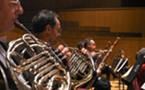 Musicians in orchestra pit playing horn instruments