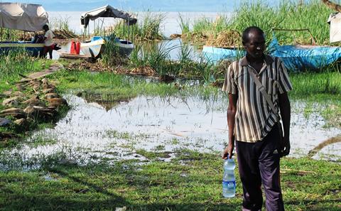 Fisherman in Arba Minch (Ethiopia) with a bottle of water extracted from a contaminated river