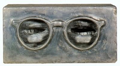 Abstract image of a black, grey and white of mouths appearing in the reflection of a pair of reading glasses