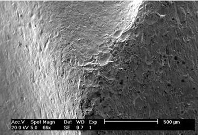 Wear scar showing individual sand particle impact craters 