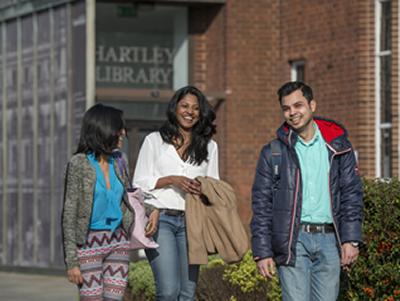 Students smiling by Hartley Library