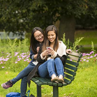 Two women sat on park bench