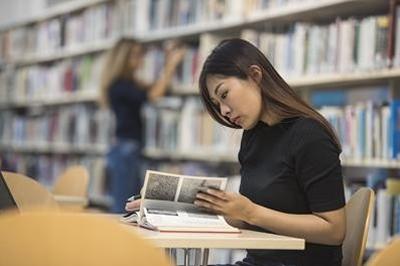 Student reading in a library