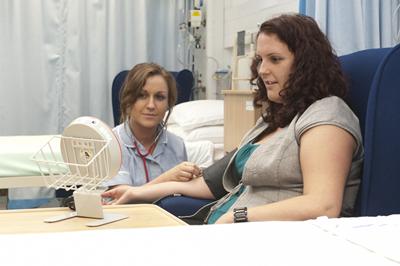 Nurse takes patient's blood pressur