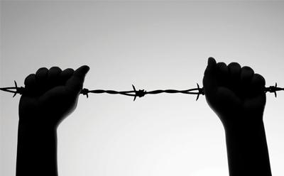 Hands holding barbed wire
