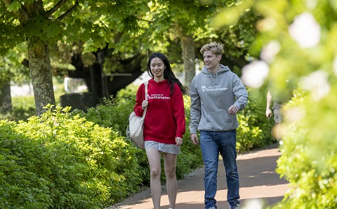 Two students wearing University hoodies Red and Grey