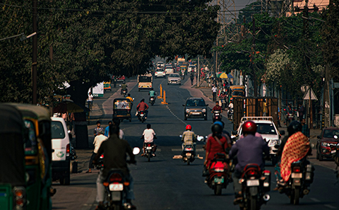 Mopeds and cars on busy street