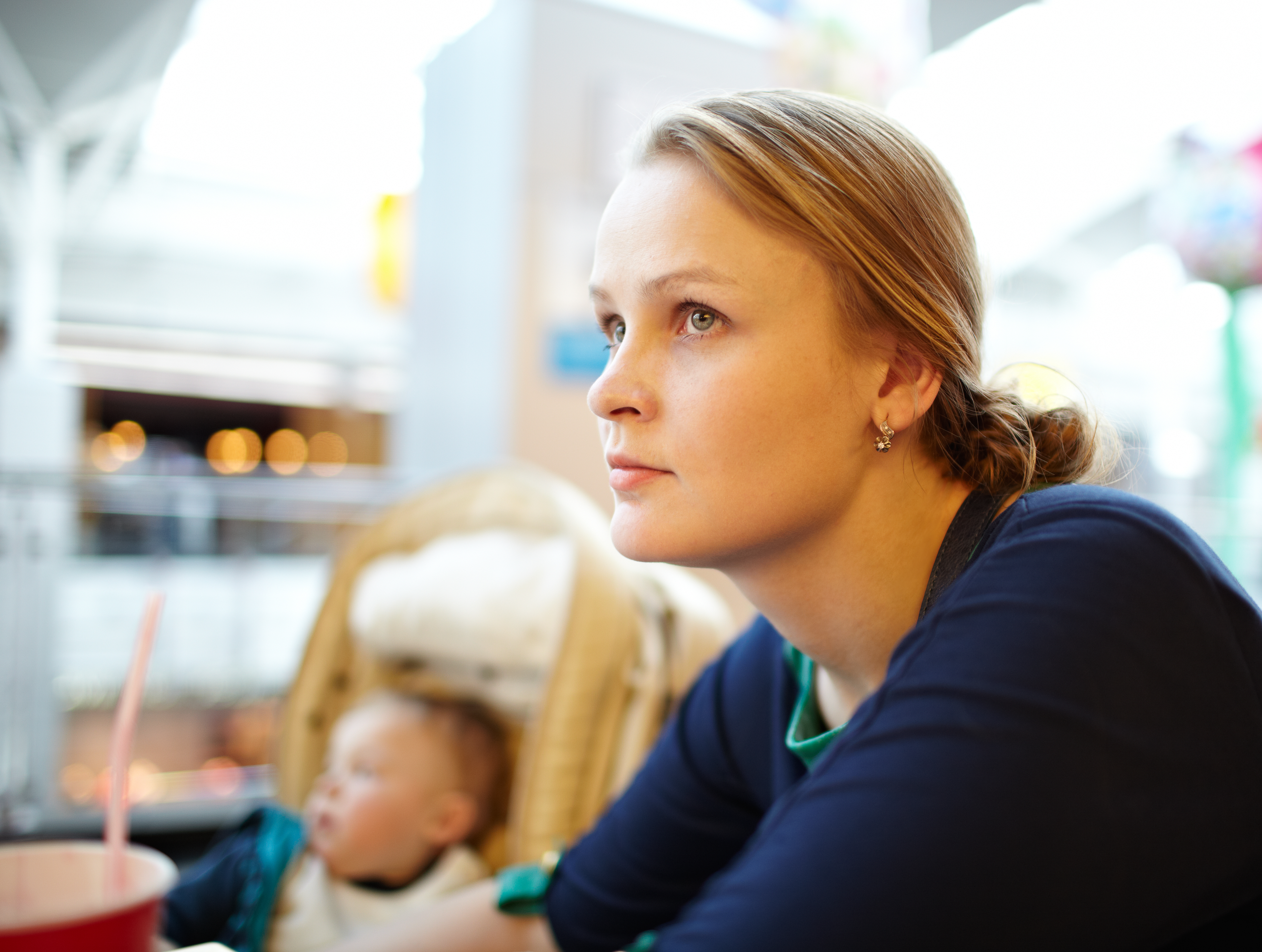 Young mother looking sad while sat with child