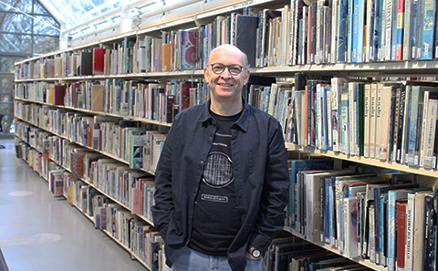 Man standing in front of book shelves