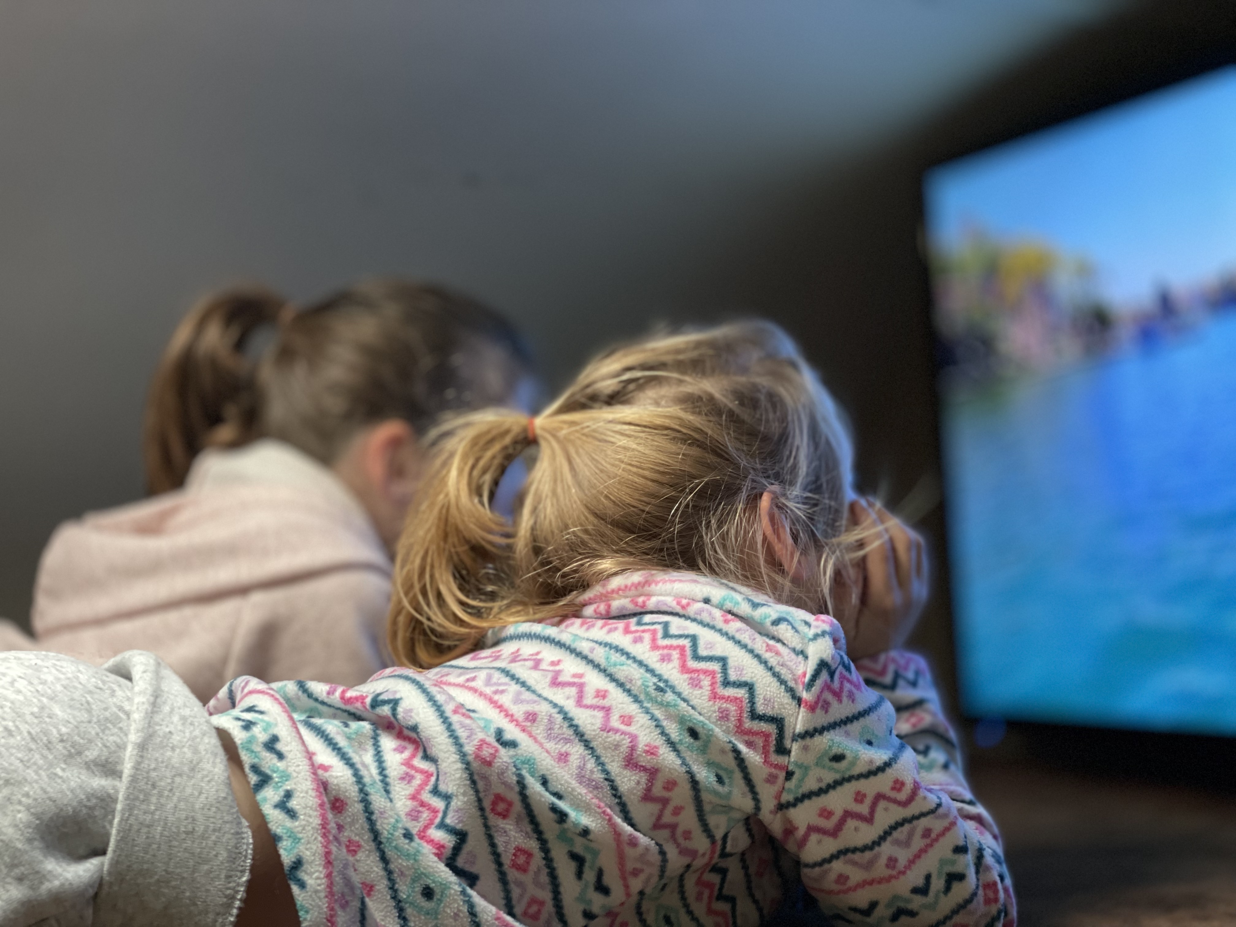 Children sit and watch TV