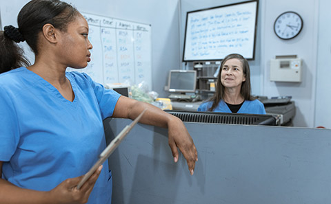 Two nurses talking in office space