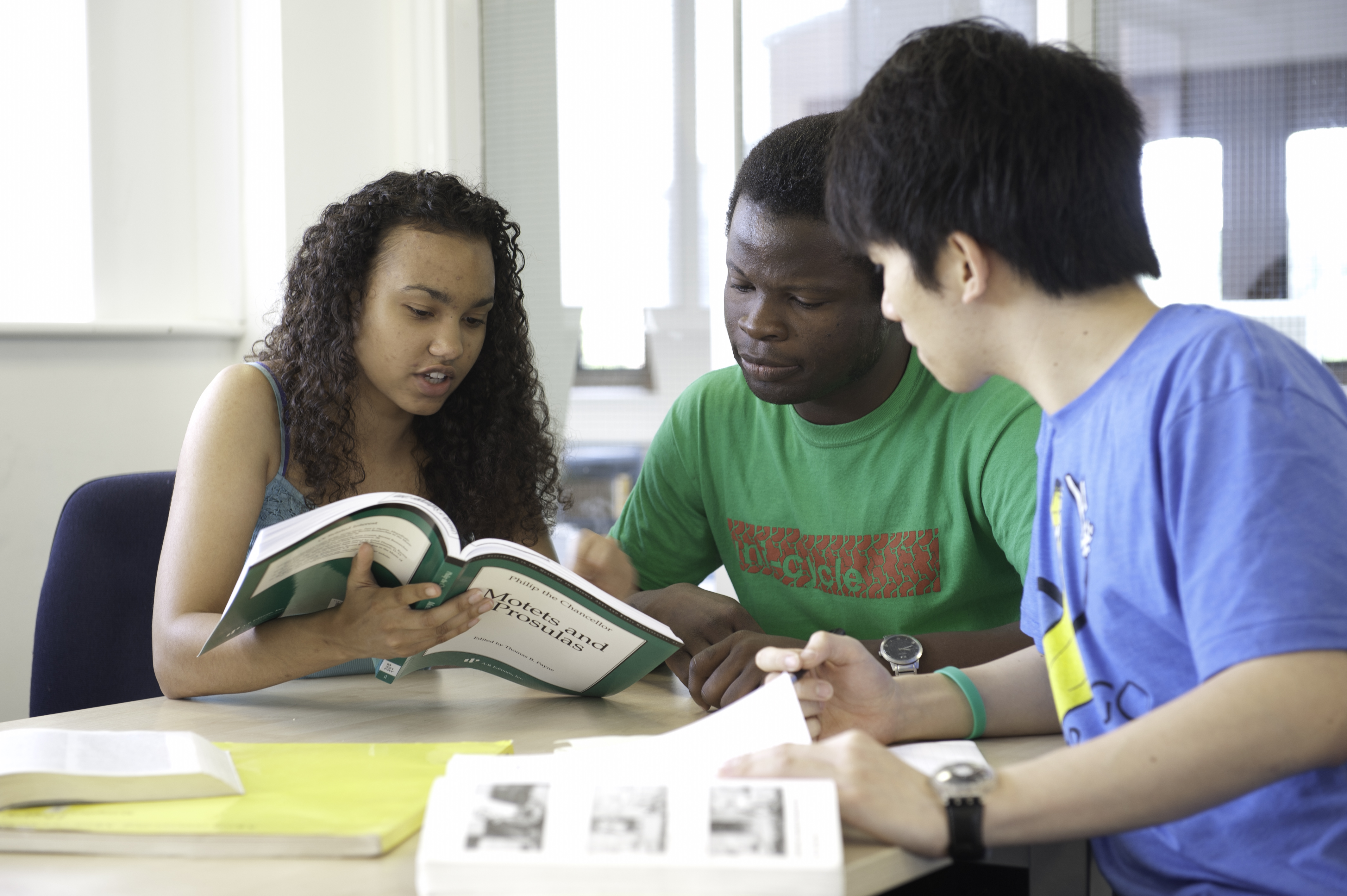 3 students reading a book