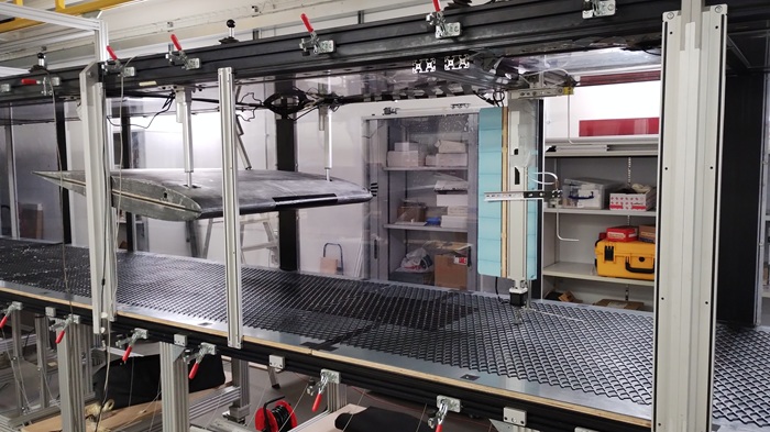 Aircraft wing model mounted in a wind tunnel test section for aerodynamic research and flow measurement