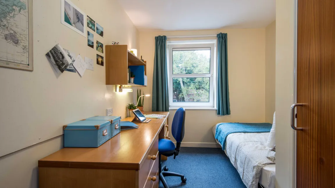 A bright, airy student bedroom with desk and single bed.