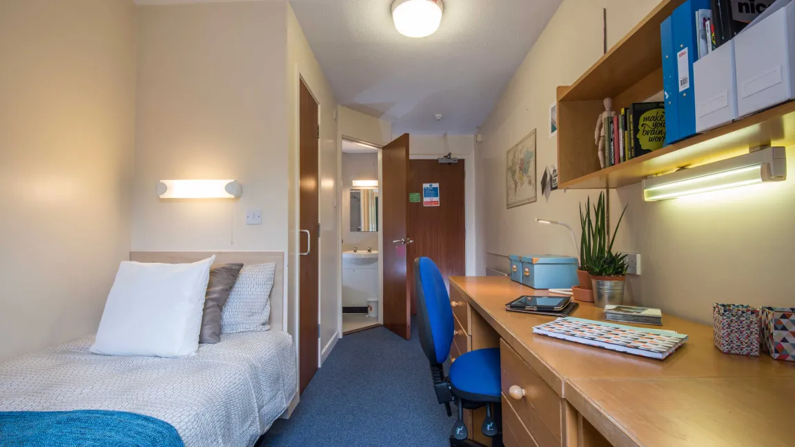 A bright, airy student bedroom with desk and single bed.