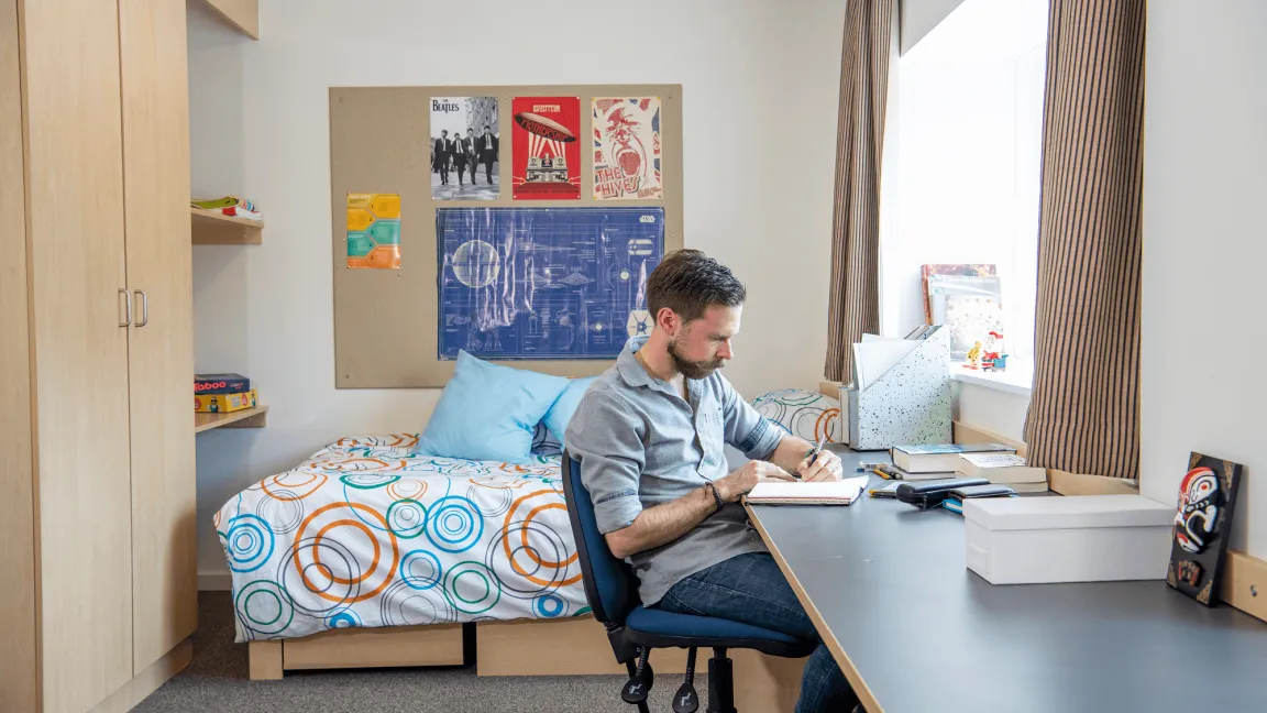 A student sitting in his studio flat.