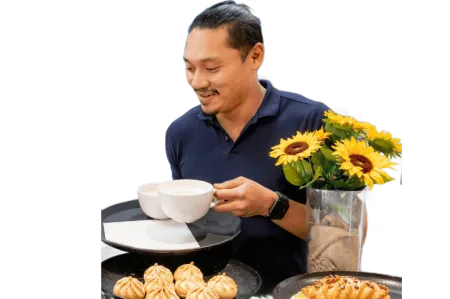 Catering manager Fritz Apellido smiles as he puts coffees on a tray