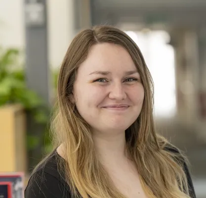 Head and shoulders portrait image of Eleanor Austin, MA Creative Writing student, smiling at the camera.