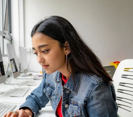 Head and shoulders portrait image of Lavanya Sharma, BA Fashion Marketing with Management student working on a laptop.