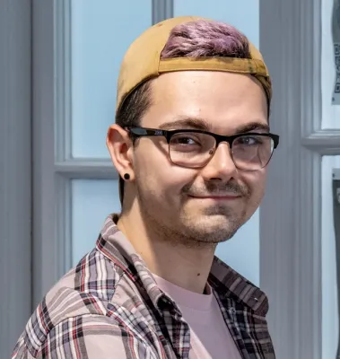 Head and shoulders portrait image of Samuel Pegg, MA Creative Writing student, smiling at the camera.