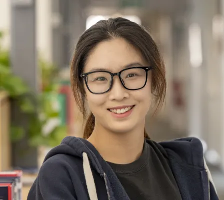 Head and shoulders portrait image of Shuheng Zhang, MA Creative Writing student, smiling at the camera.
