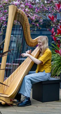 BA Music student Tenzi Williams playing a harp