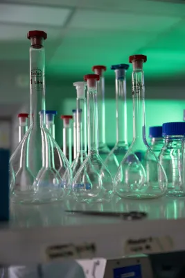 Volumetric flasks and laboratory glassware arranged on a research bench.