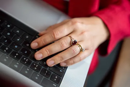 Dr Larisa Yarovaya using a laptop keyboard, wearing rings, while working.