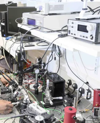 Photonics equipment on a lab work bench and shelf.