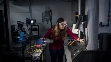 A student uses a piece of equipment in the testing and structures research lab