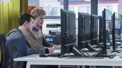 Two students working at a computer in the David Barron computing lab.