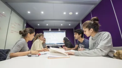 Group of students at work around a table in the maths student centre.