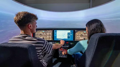 Two students at the controls of the flight simulator