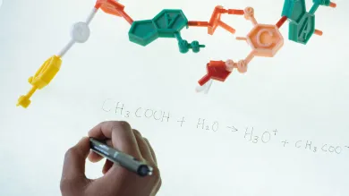 Chemical equation written on a whiteboard with red, green and orange pen