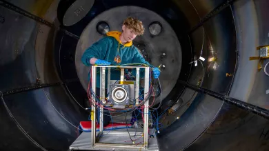 A student works on an experiment in the electric propulsion lab