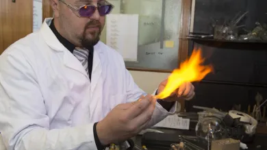 A glass expert uses scientific glassblowing equipment