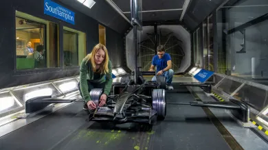Two students work conduct a race car experiment in the R J Mitchell wind tunnel