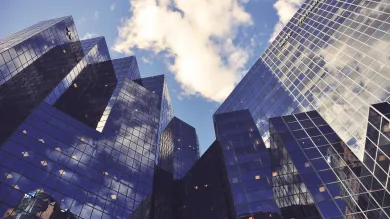 Low-angle view of city office buildings reflecting the sky