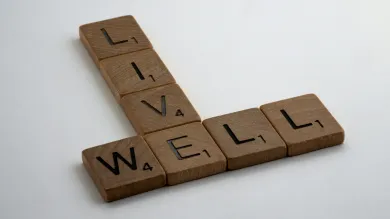Wooden Scrabble pieces spelling out the words Live Well