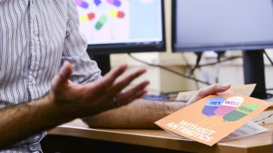 A hand holding a get well without antibiotics card