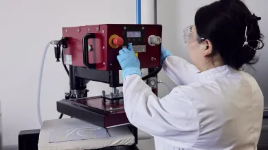 A woman researcher using a machine at the e-textile laboratory