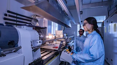A man and a woman doing preform fabrication on MCVD lathe