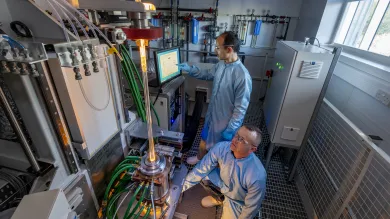 Two men building microstructured fibre preform in furnace