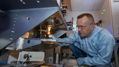 A man working with fibre drop out of the furnace