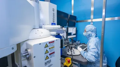 A woman working on SNC - Zeiss NVision40 SEM/FIB equipment
